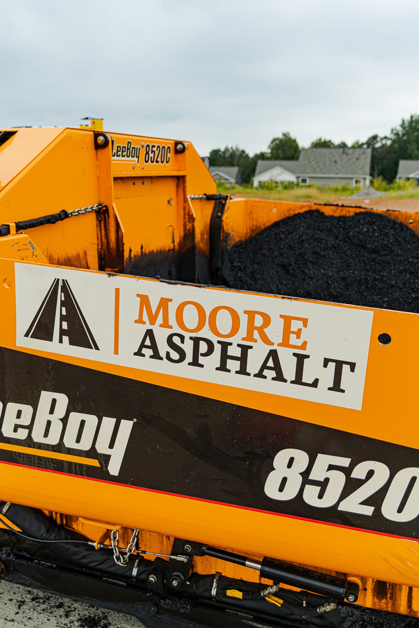 Moore Asphalt paver loaded with fresh asphalt