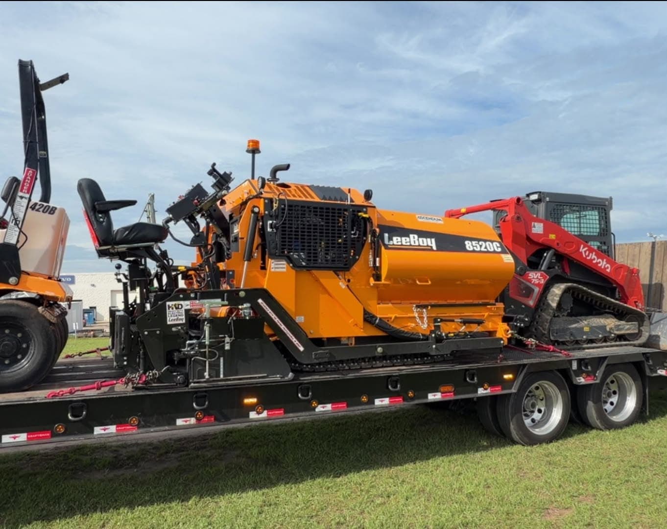 Moore Asphalt paver and track loader on an equipment trailer